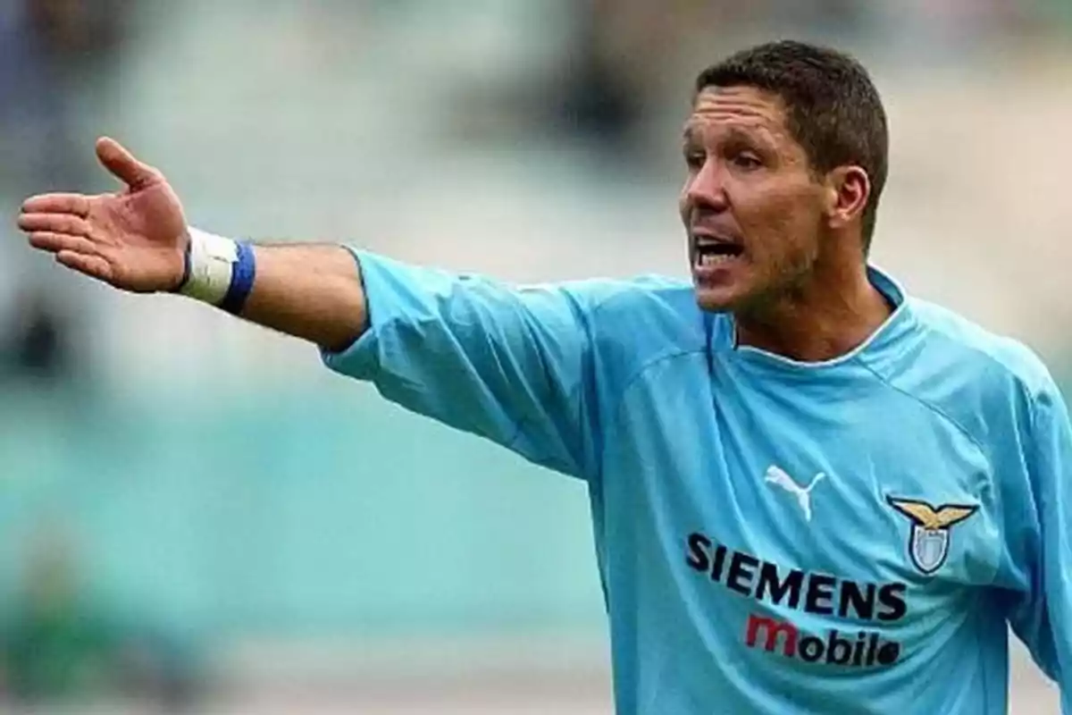 A football player in a light blue uniform gesturing with his outstretched hand.