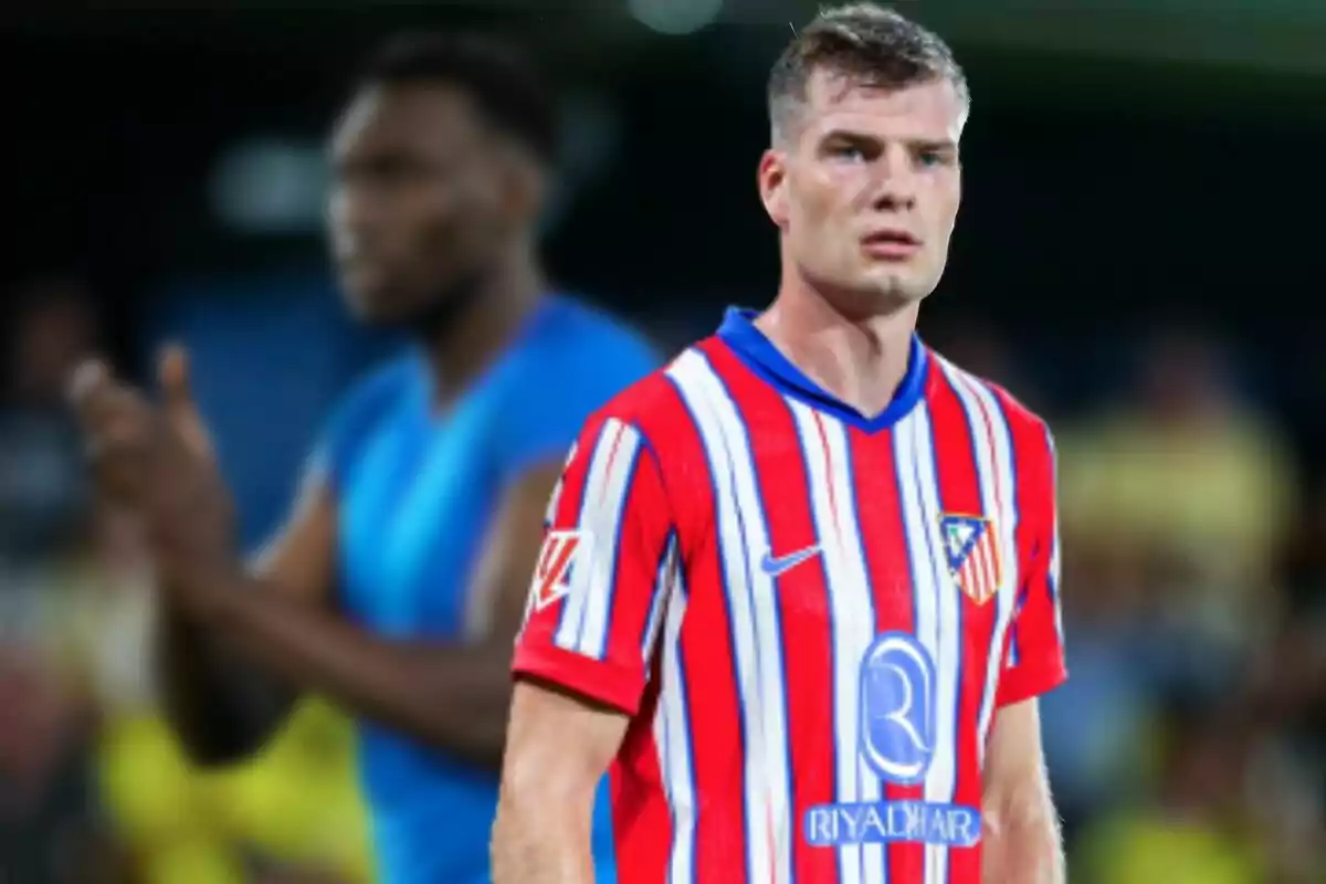 A football player wearing an Atlético de Madrid shirt on a football pitch.