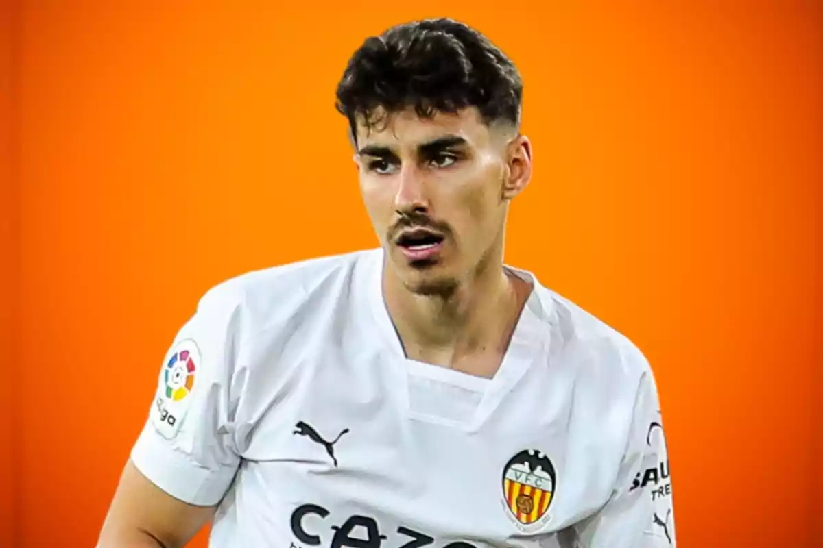 A soccer player in a white Valencia CF shirt and an orange background.