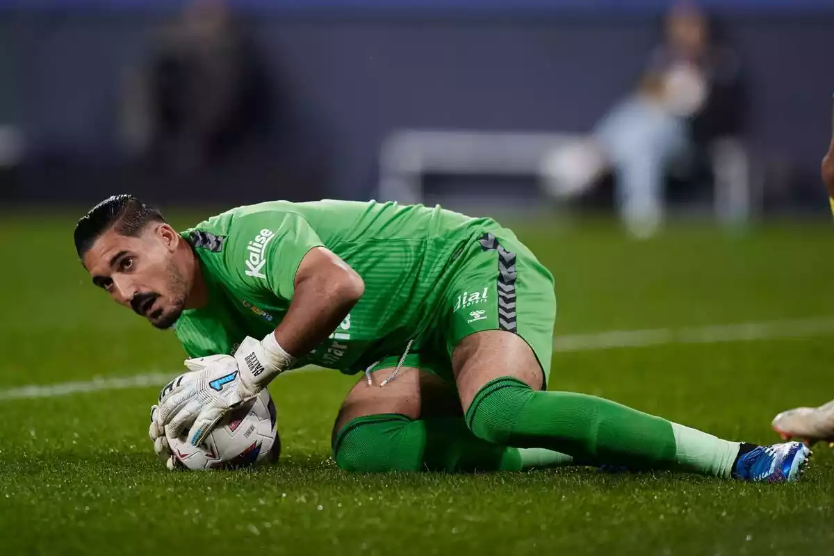 Álvaro Valles stops a ball and looks down with the ball in his hands