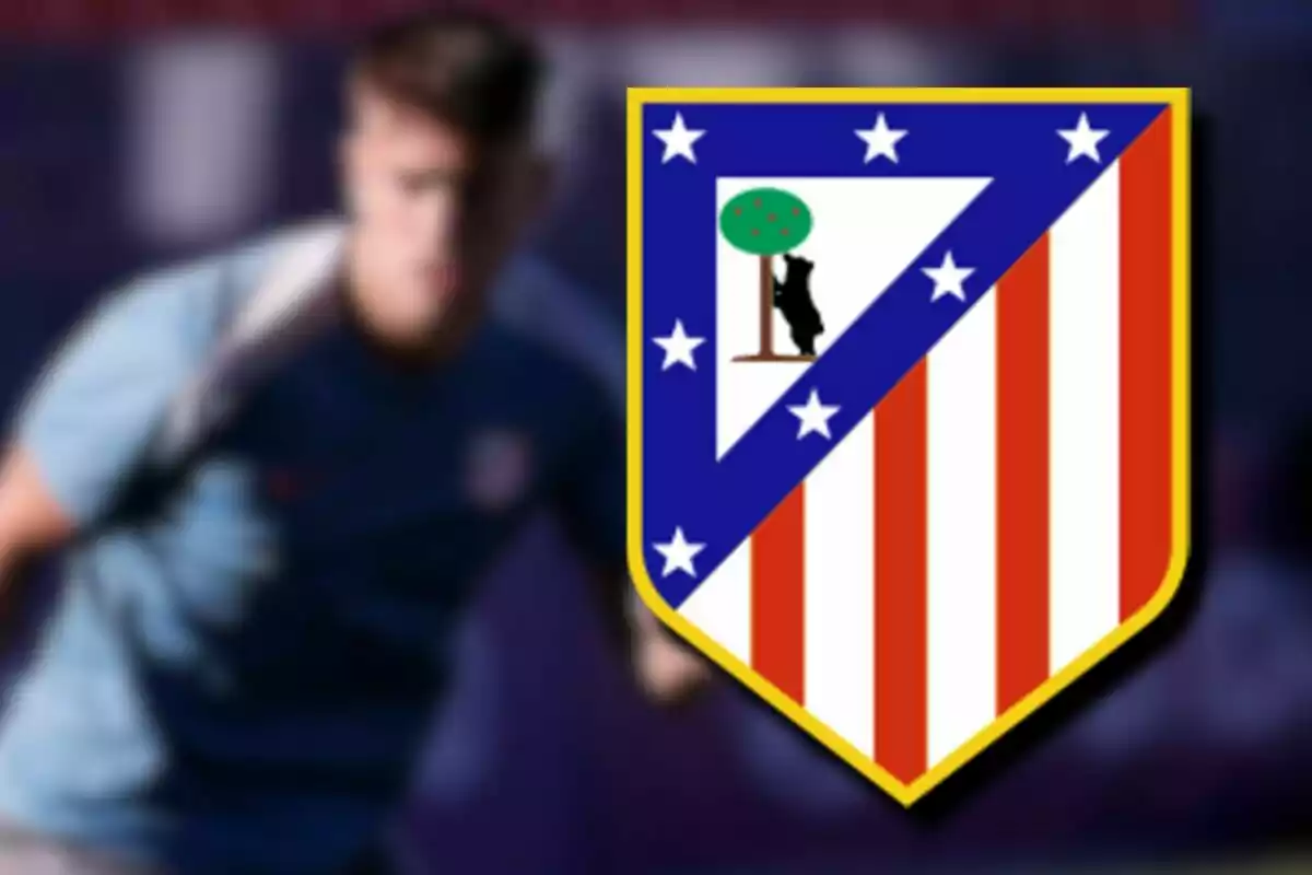 Atlético de Madrid crest with a blurred person in the background.