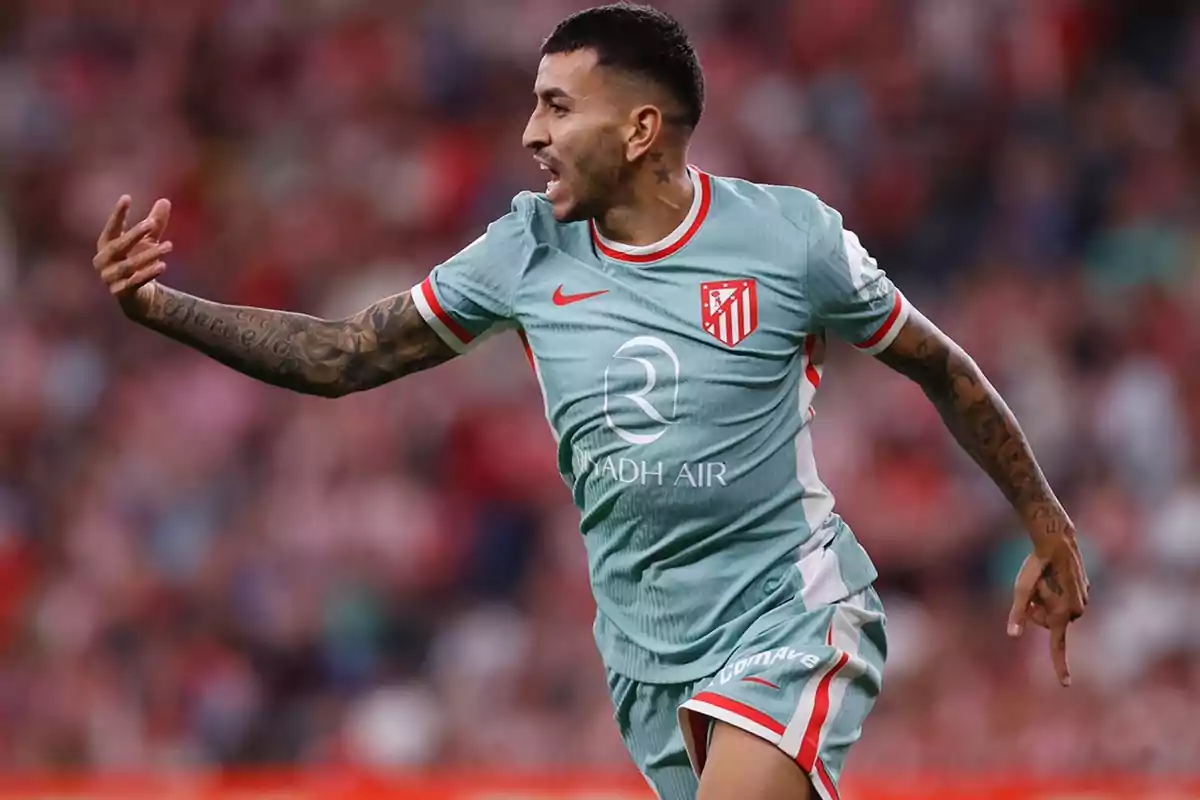 Football player celebrating a goal in the Atlético de Madrid uniform during a match.