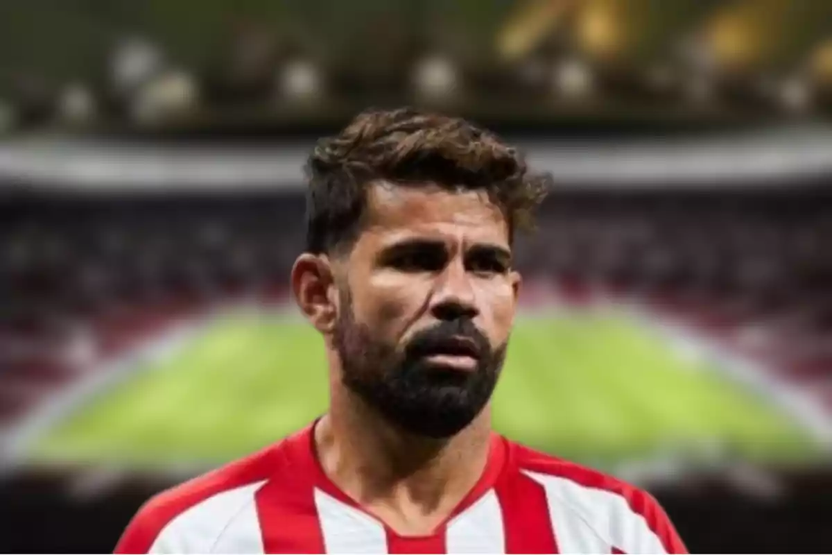 A soccer player in a red and white uniform in a stadium.