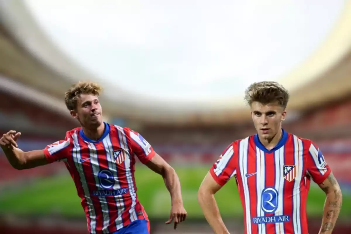 Two football players wearing Atlético de Madrid uniforms in a stadium.