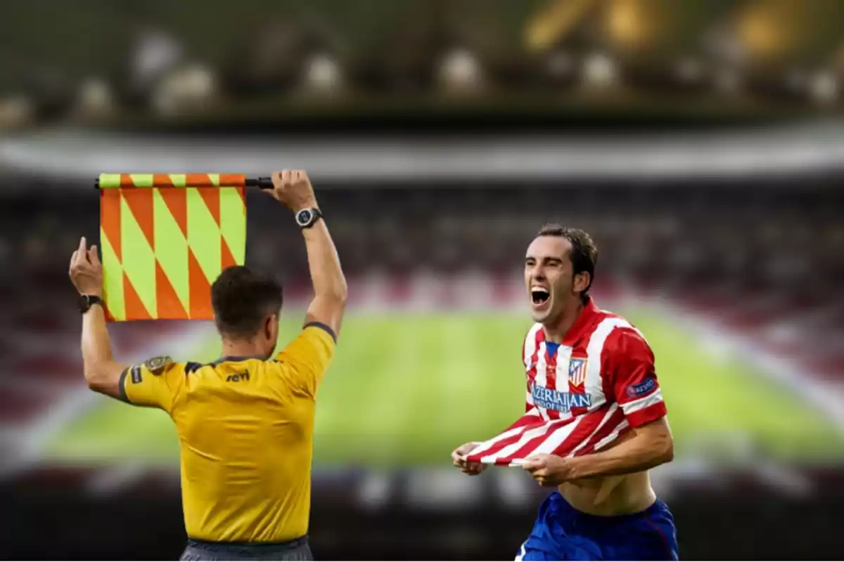 An assistant referee raises his flag as a soccer player celebrates effusively in a stadium.