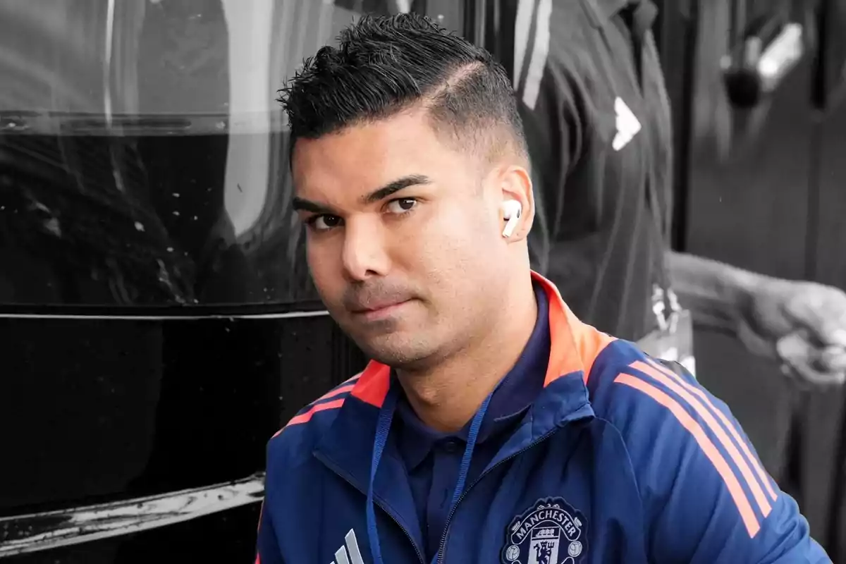 A man in a Manchester United jacket and white headphones.