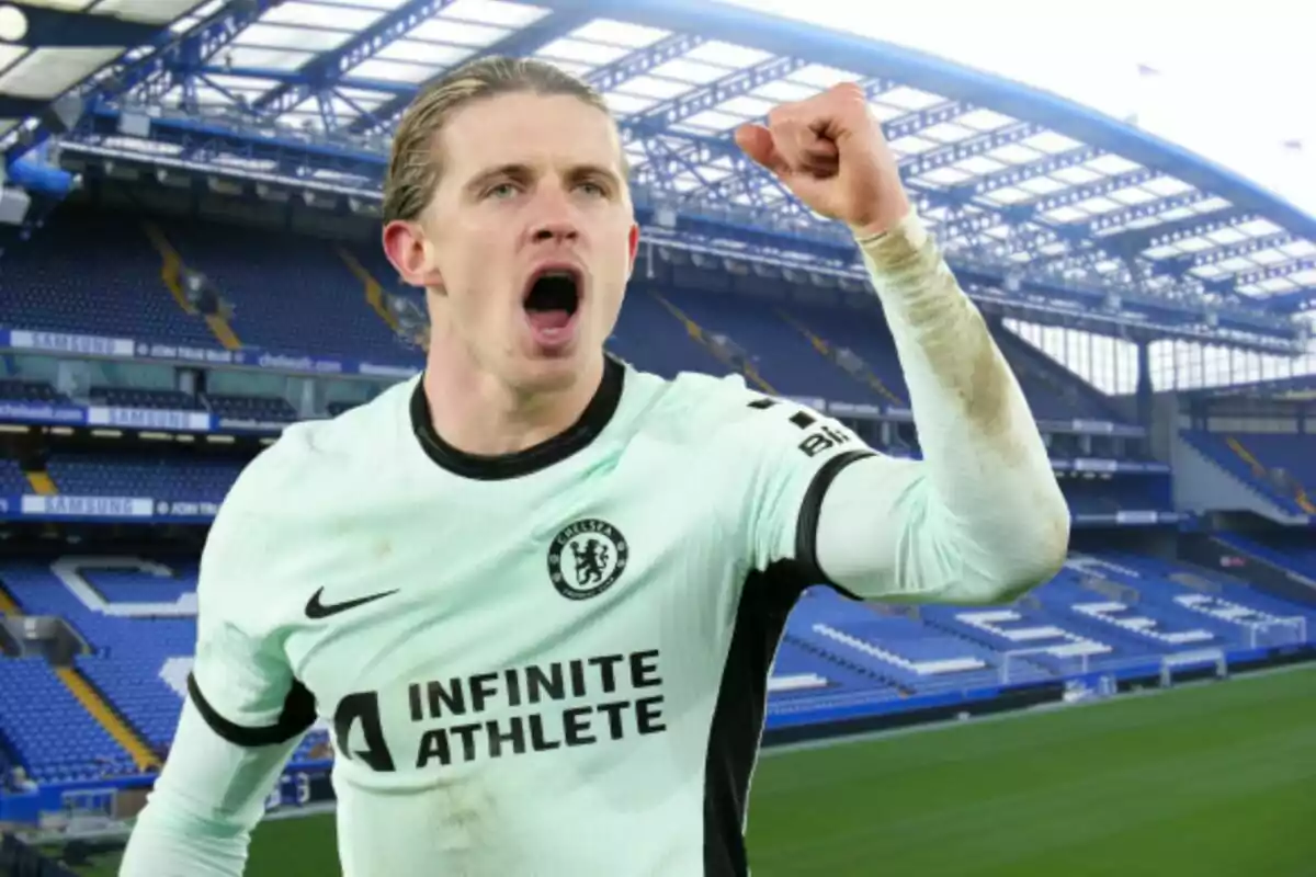 A soccer player celebrates with his fist raised in an empty stadium.