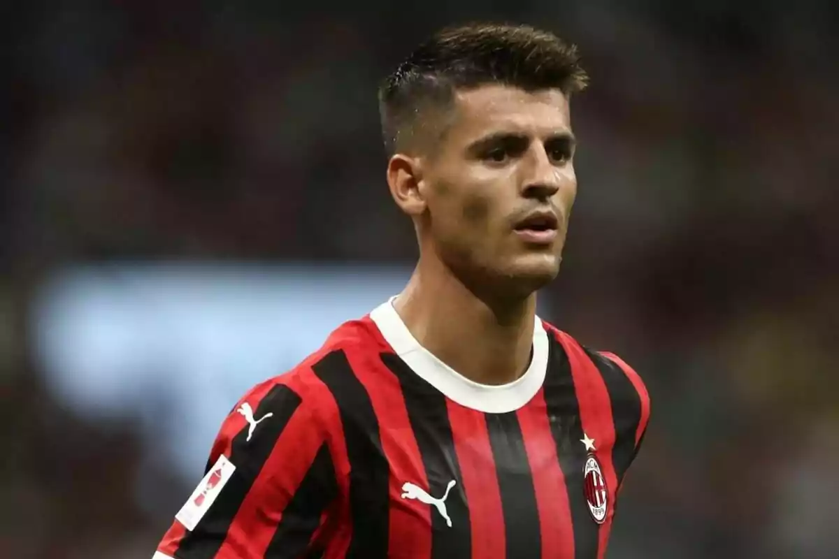 Football player in AC Milan jersey on the playing field.