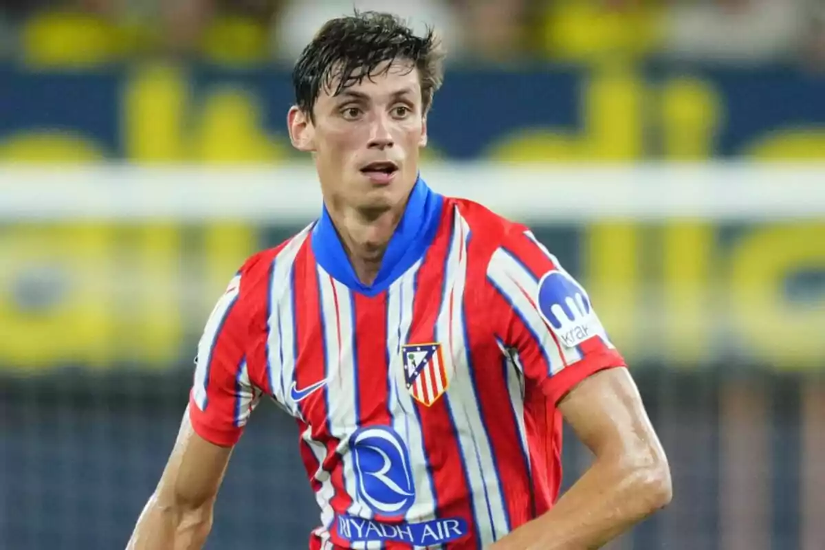 Football player wearing Atlético de Madrid shirt on the playing field.