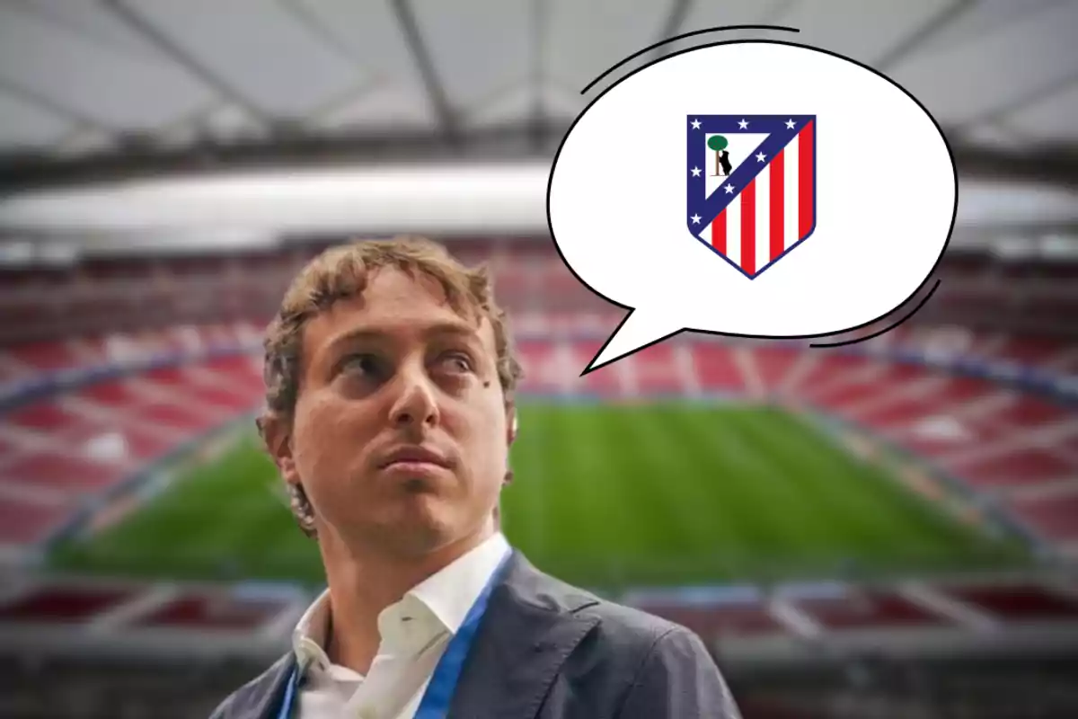 A man in a suit and tie stands in an empty football stadium, looking to the side, with a speech bubble containing the Atlético de Madrid crest.