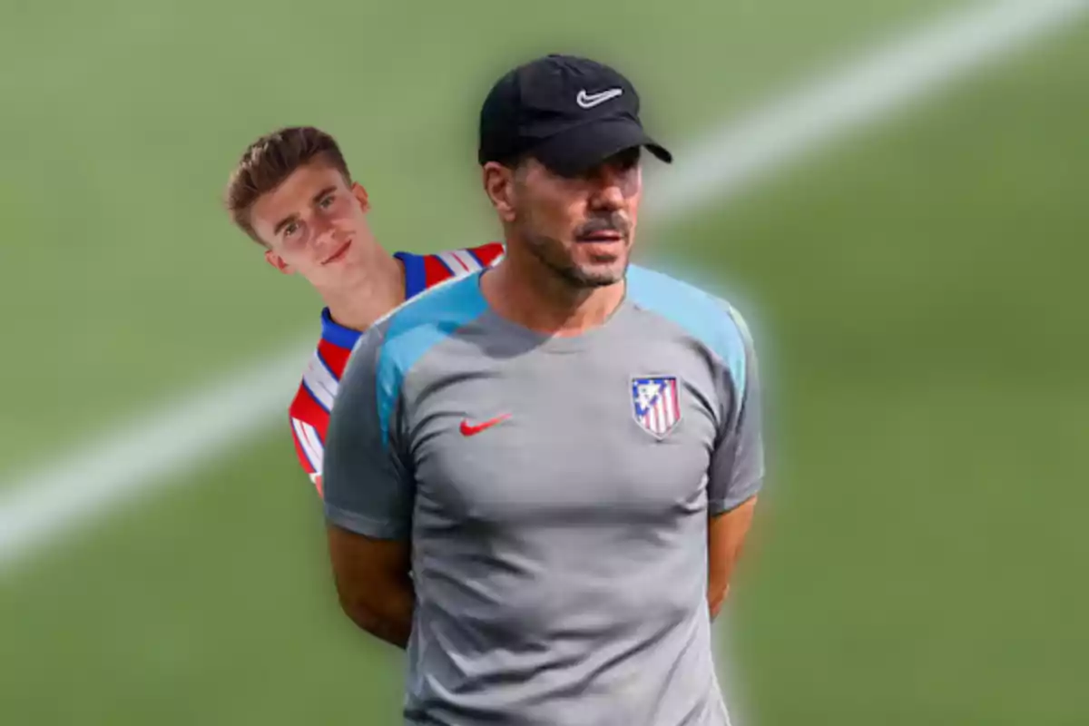 Two men wearing Atlético de Madrid sportswear, one wearing a red and white striped shirt and the other wearing a grey shirt and black cap, against a football field background.