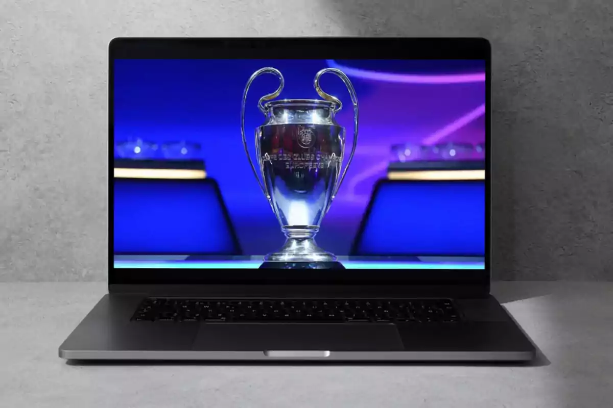 A laptop displaying an image of the UEFA Champions League trophy on its screen.