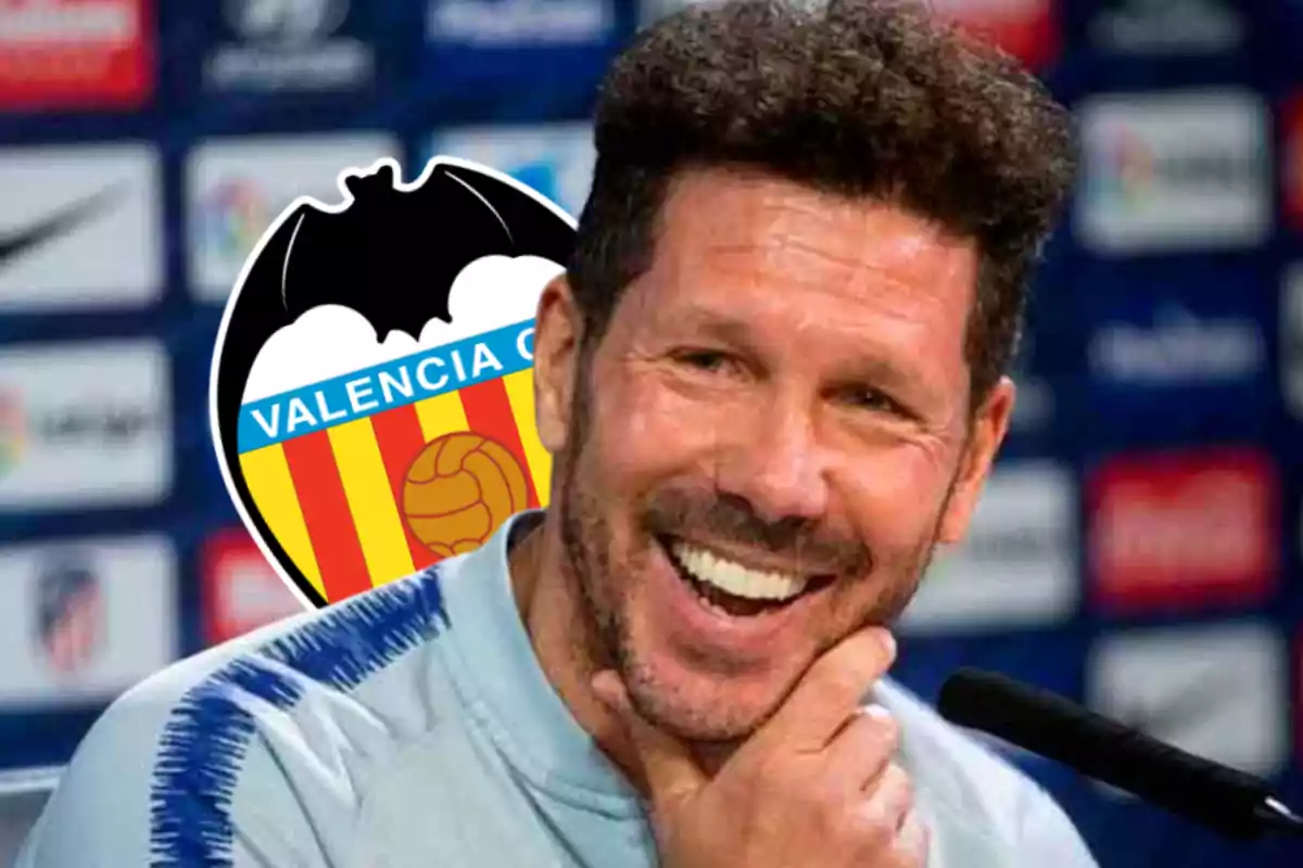 Smiling man with Valencia CF logo in the background.