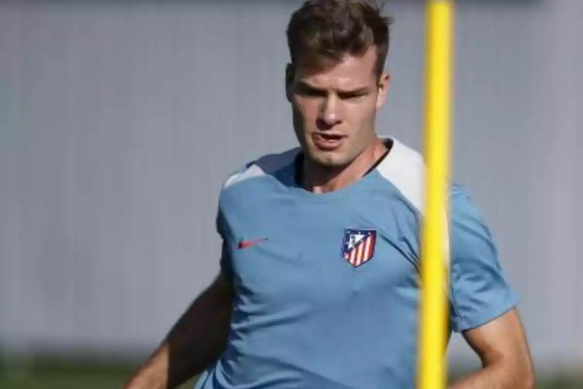 A football player wearing an Atlético de Madrid training shirt.