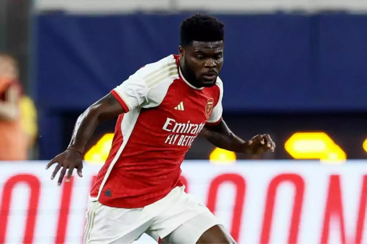 An Arsenal football player in a red and white uniform in action during a match.