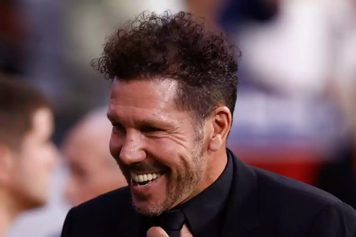 Smiling man in black suit at an event.