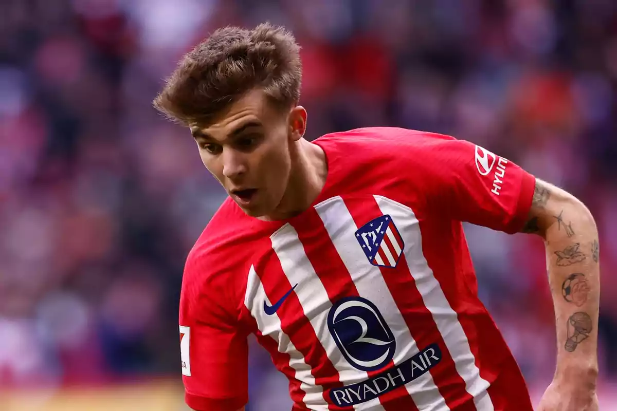 Football player wearing an Atlético de Madrid shirt in action during a match.