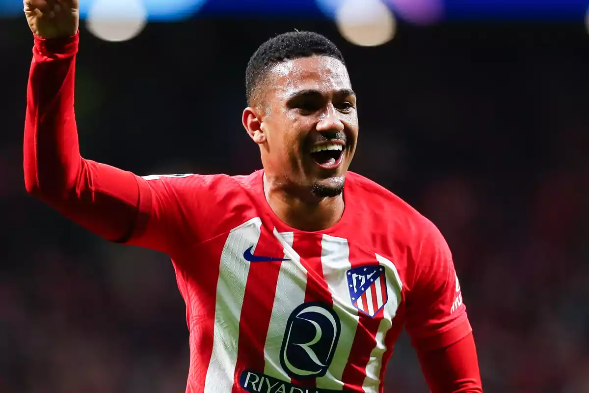 Football player in Atlético de Madrid uniform celebrating on the field.