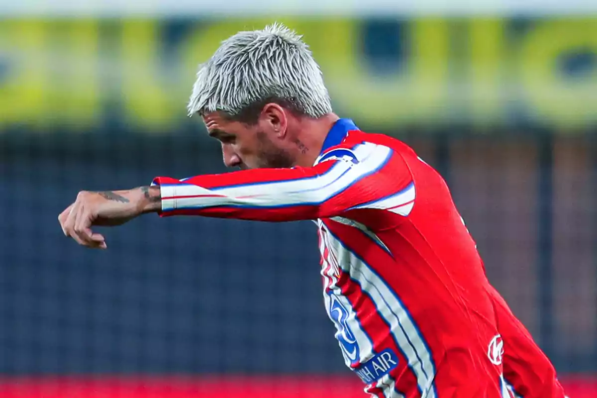 Soccer player with blonde hair and red uniform in action during a match.