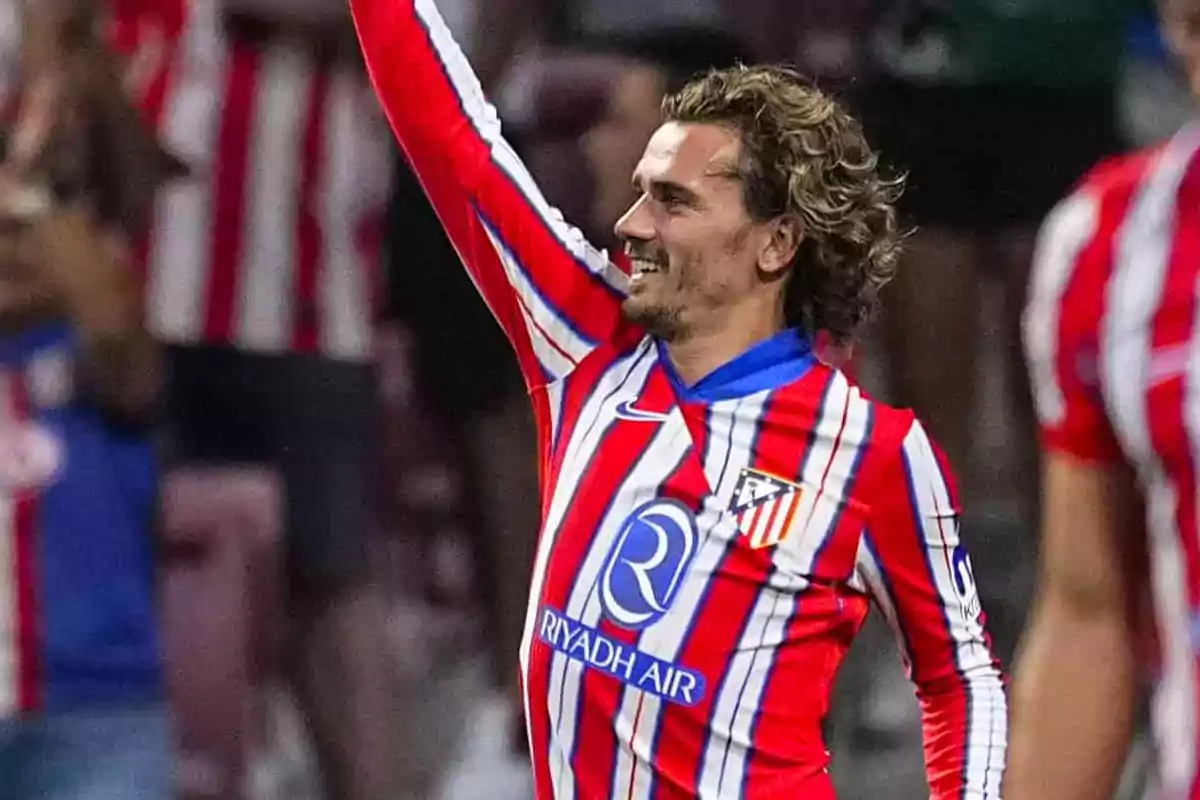 Soccer player in red and white uniform celebrating on the field.