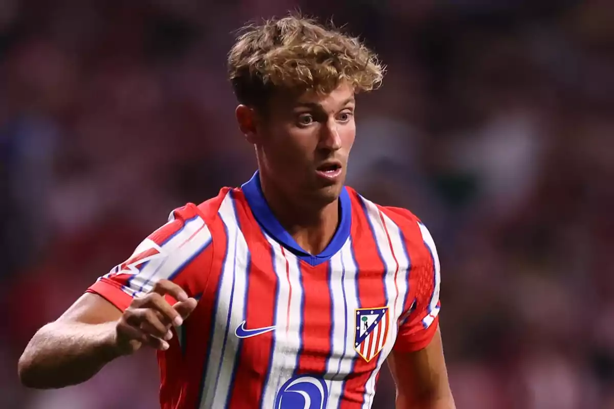 A football player wearing an Atlético de Madrid shirt on the pitch.