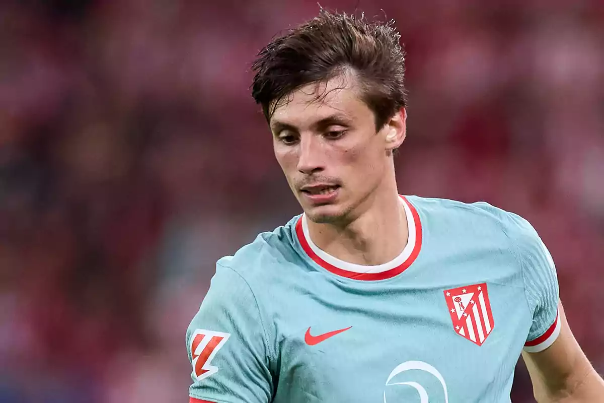 Football player wearing a light blue Atlético de Madrid shirt during a match.