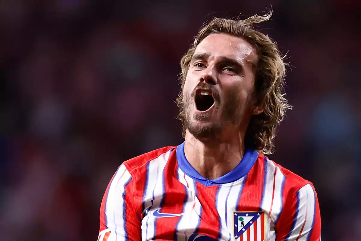 Football player wearing an Atlético de Madrid shirt celebrating on the pitch.