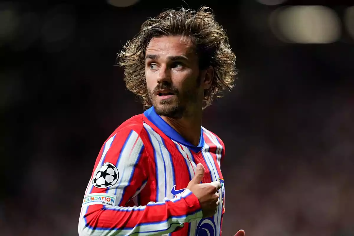 Football player wearing a red, white and blue striped shirt during a match.