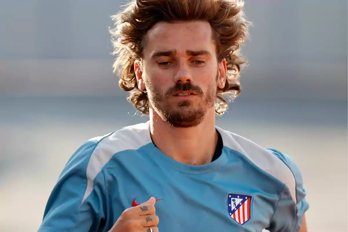 A football player in a light blue Atletico Madrid training shirt running.