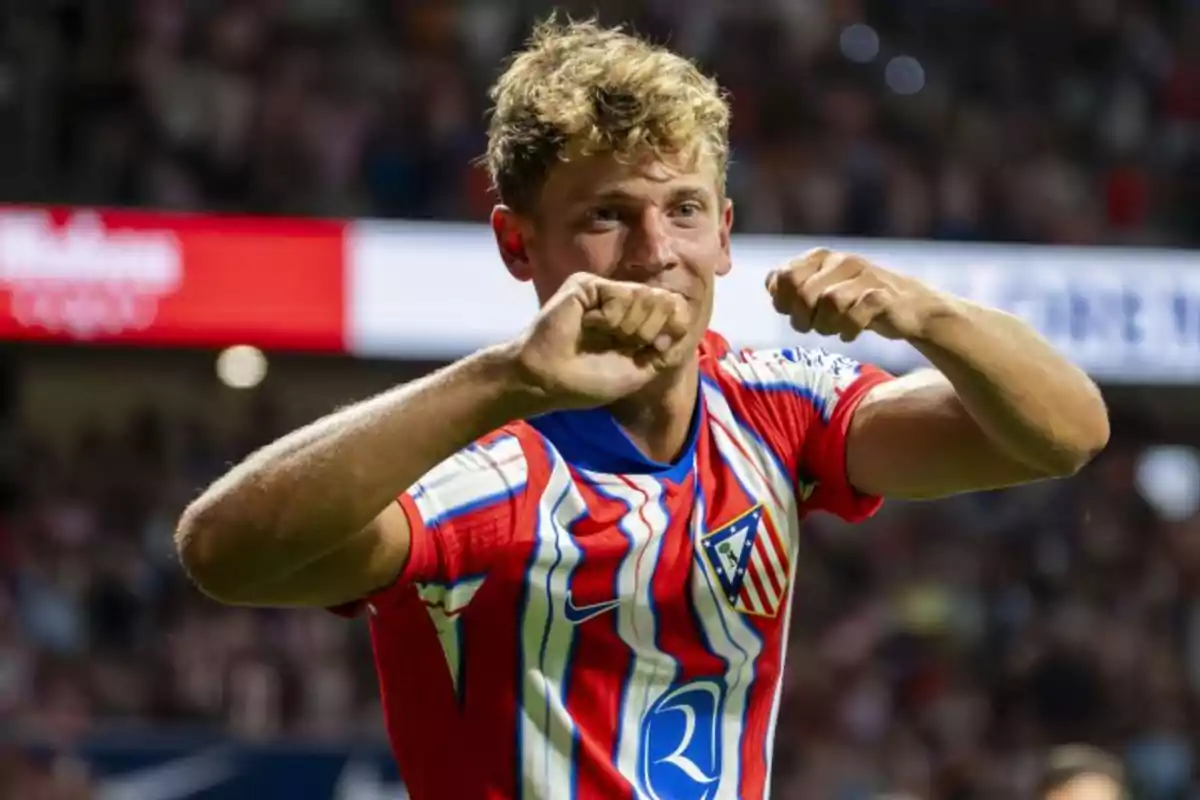 A football player celebrating a goal wearing an Atlético de Madrid shirt.