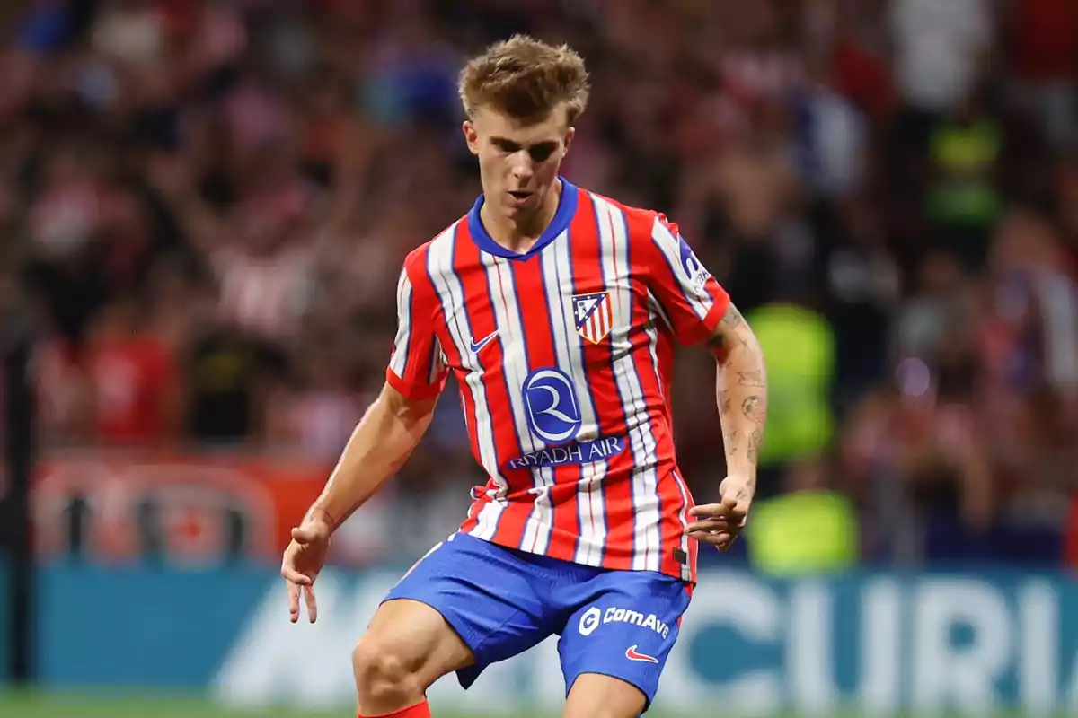 Football player in Atlético de Madrid uniform in action during a match.