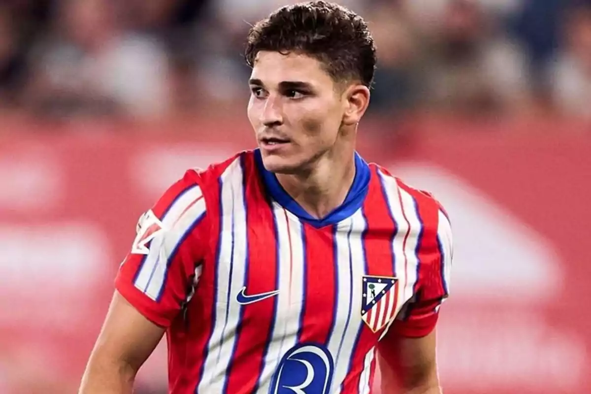 Football player wearing Atlético de Madrid shirt on the playing field.