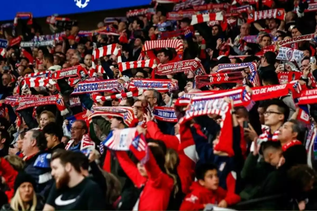 Soccer fans with red and white scarves in a stadium.