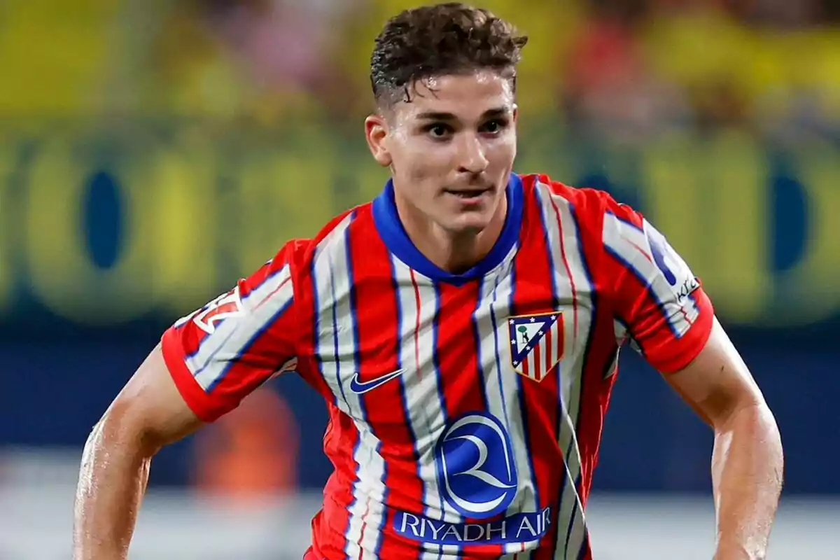 Football player wearing Atlético de Madrid shirt on the playing field.