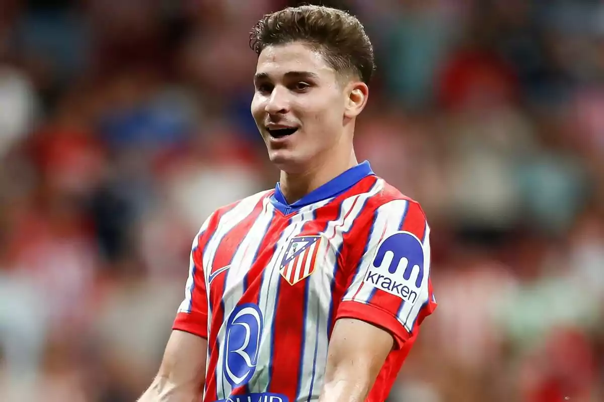 Football player wearing Atlético de Madrid shirt on the playing field.