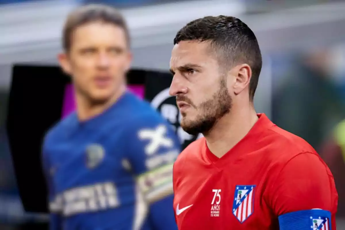 Two football players on the field, one in a red Atlético de Madrid uniform and the other in a blue uniform, both with captain's armbands.