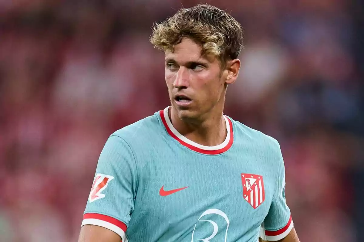 Football player wearing a light blue Atlético de Madrid shirt on the playing field.