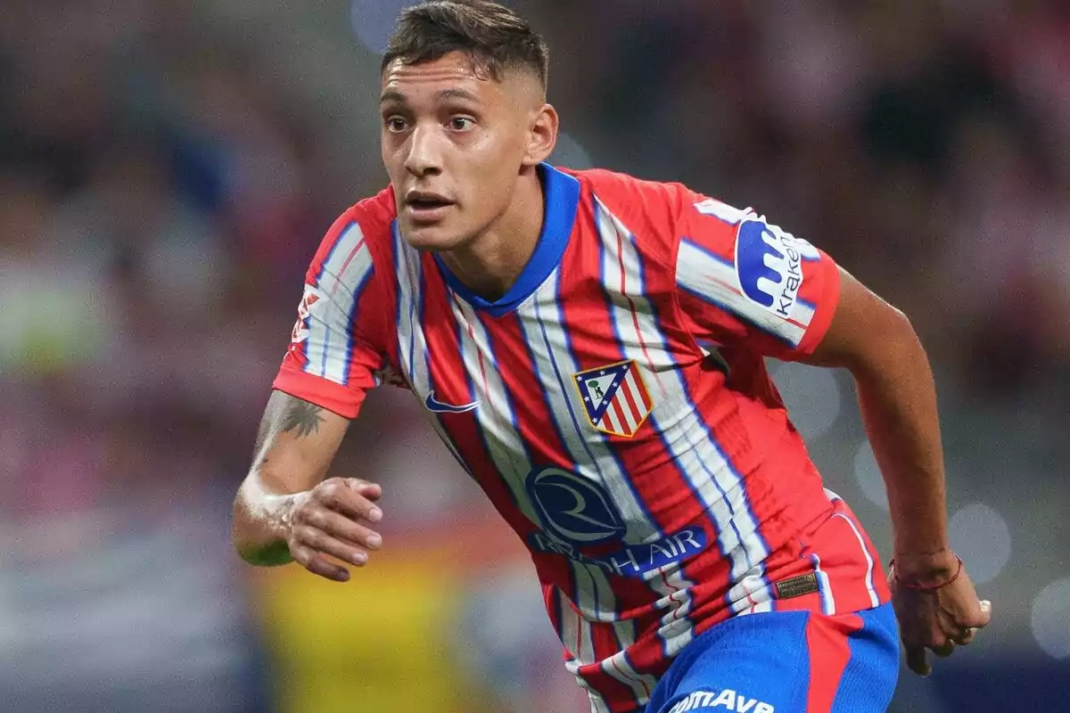 Football player in Atlético de Madrid uniform in action during a match.