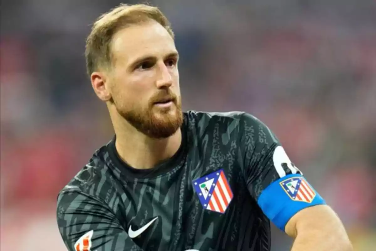 A soccer player wearing an Atlético de Madrid uniform and a captain's armband.