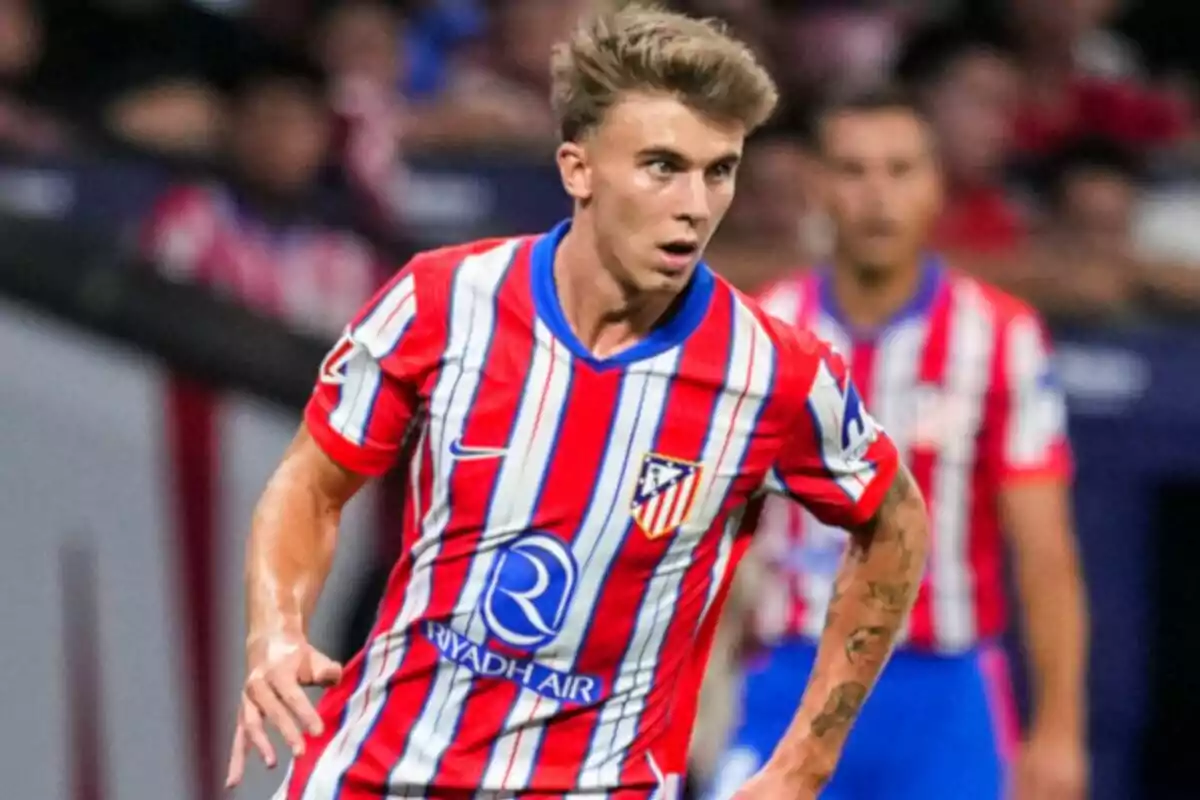 Football player in Atlético de Madrid uniform on the playing field.