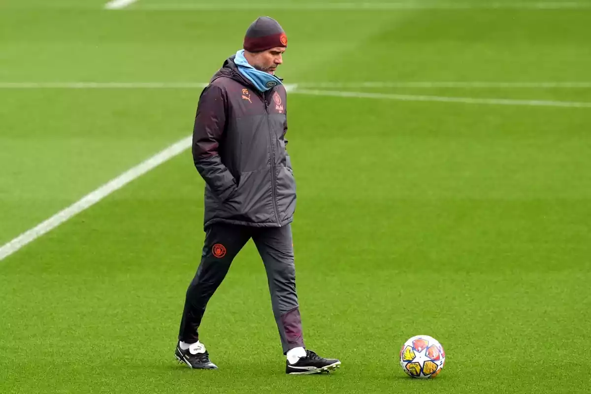 Pep Guardiola touching a ball during a Manchester City training session