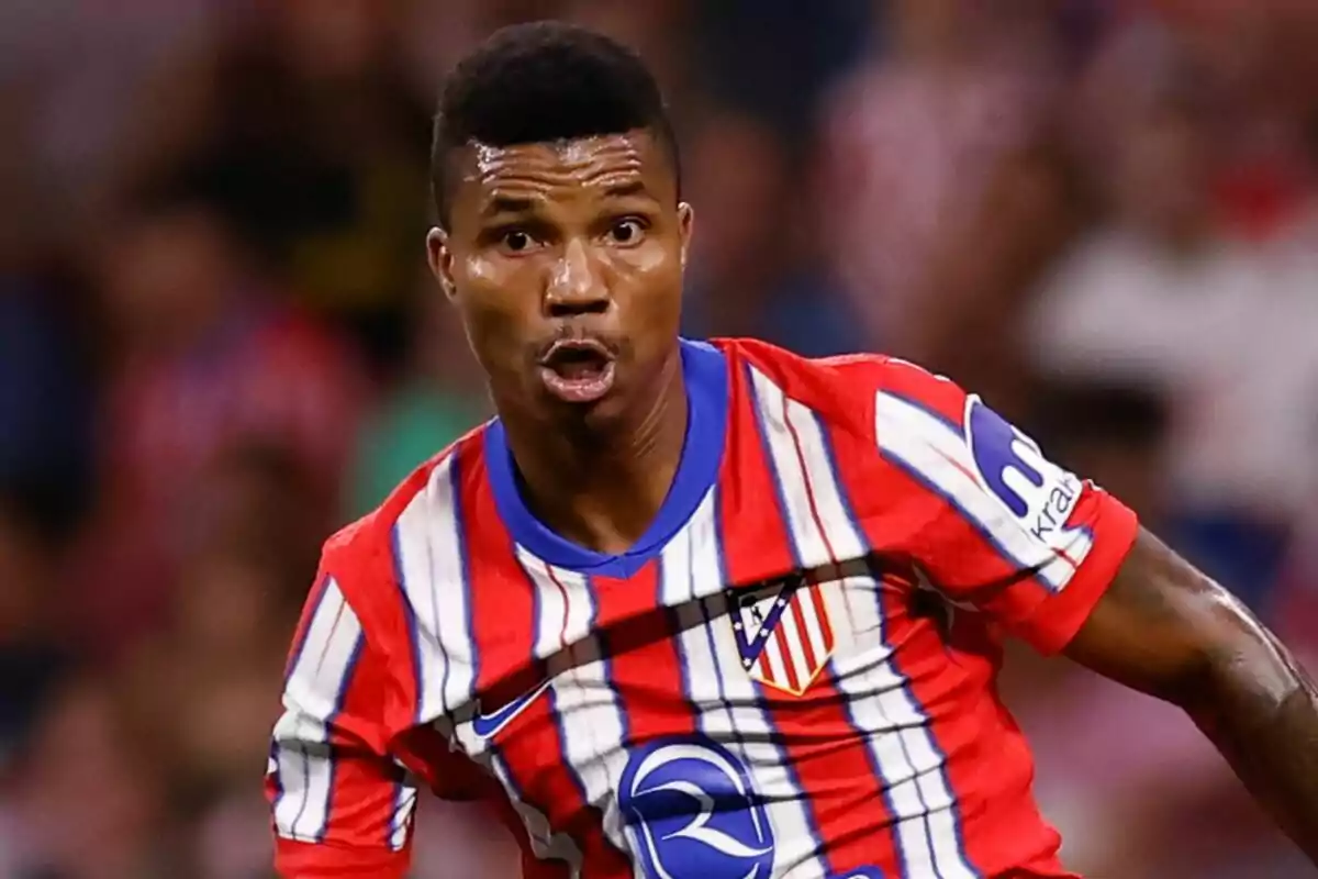 Football player in red, white and blue striped jersey in action during a match.