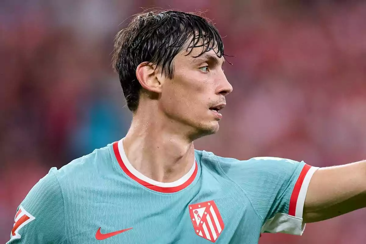 Football player wearing Atlético de Madrid shirt on the playing field.