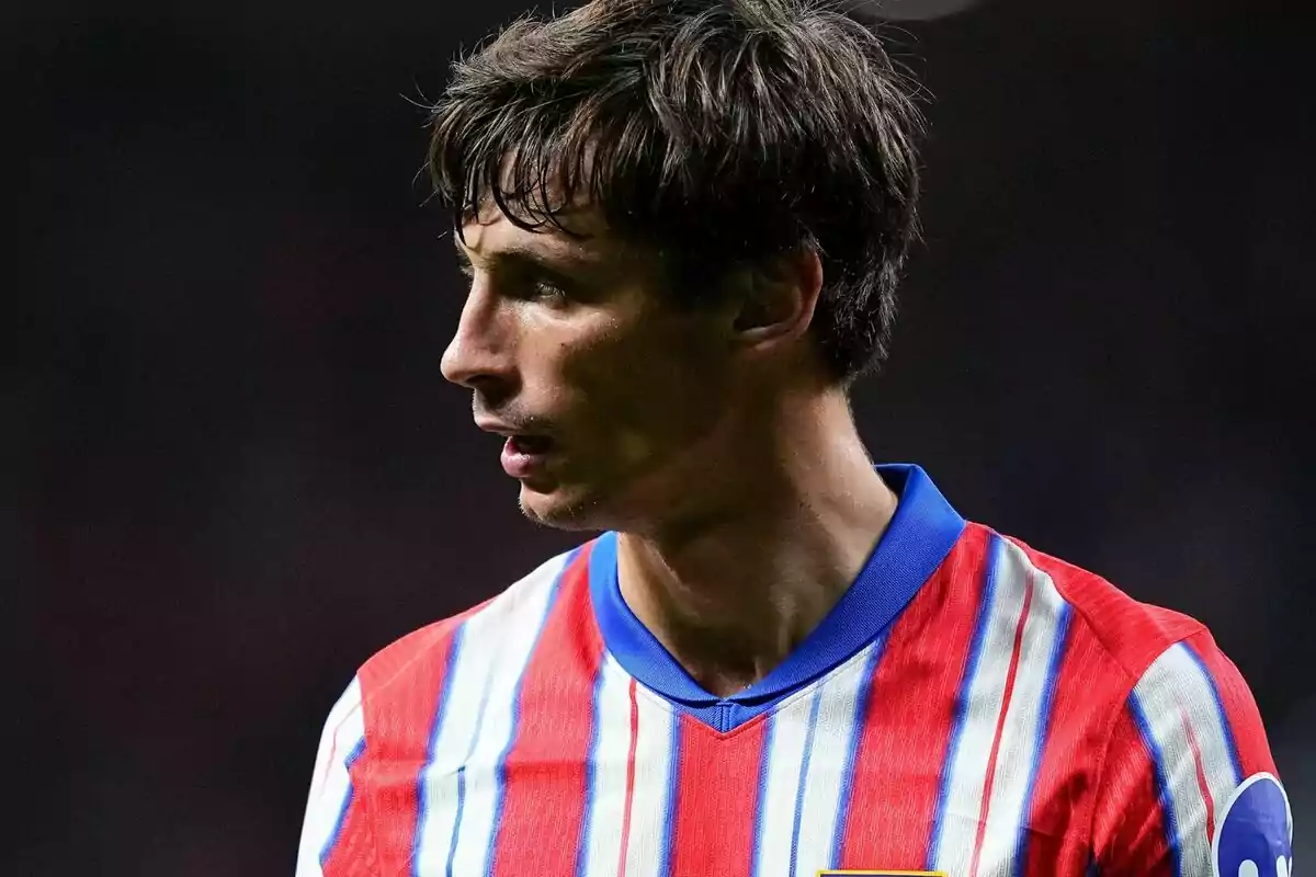 Soccer player in red, white and blue striped shirt looking left.