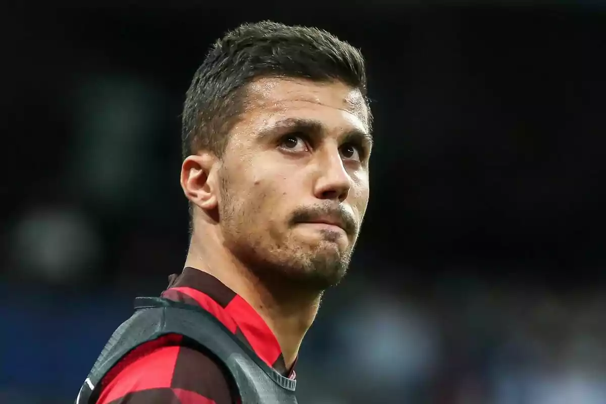 A man in a red and black football shirt looking up.