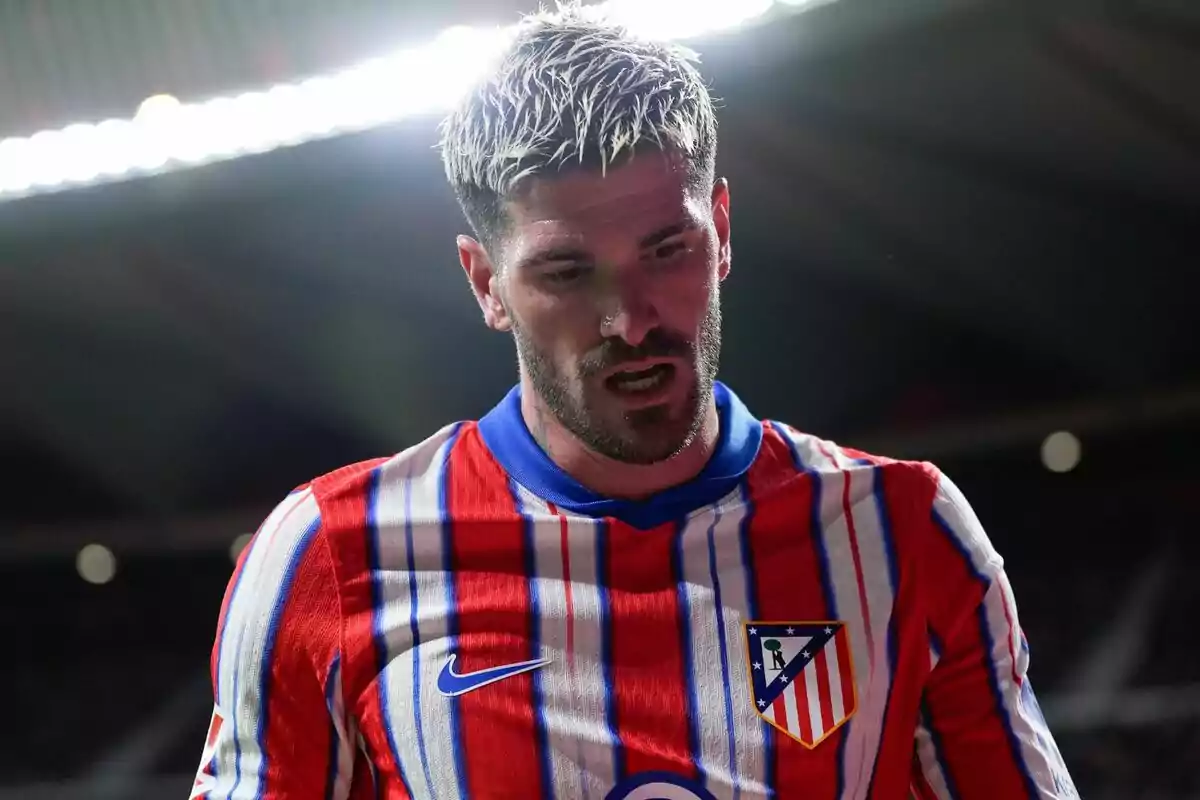 Football player wearing an Atlético de Madrid shirt in a stadium.