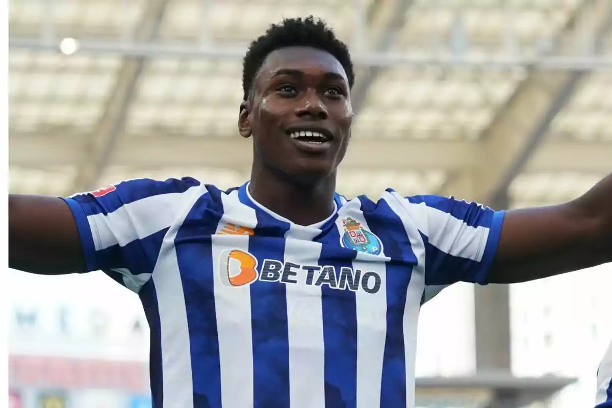 Soccer player in blue and white uniform celebrating in a stadium.