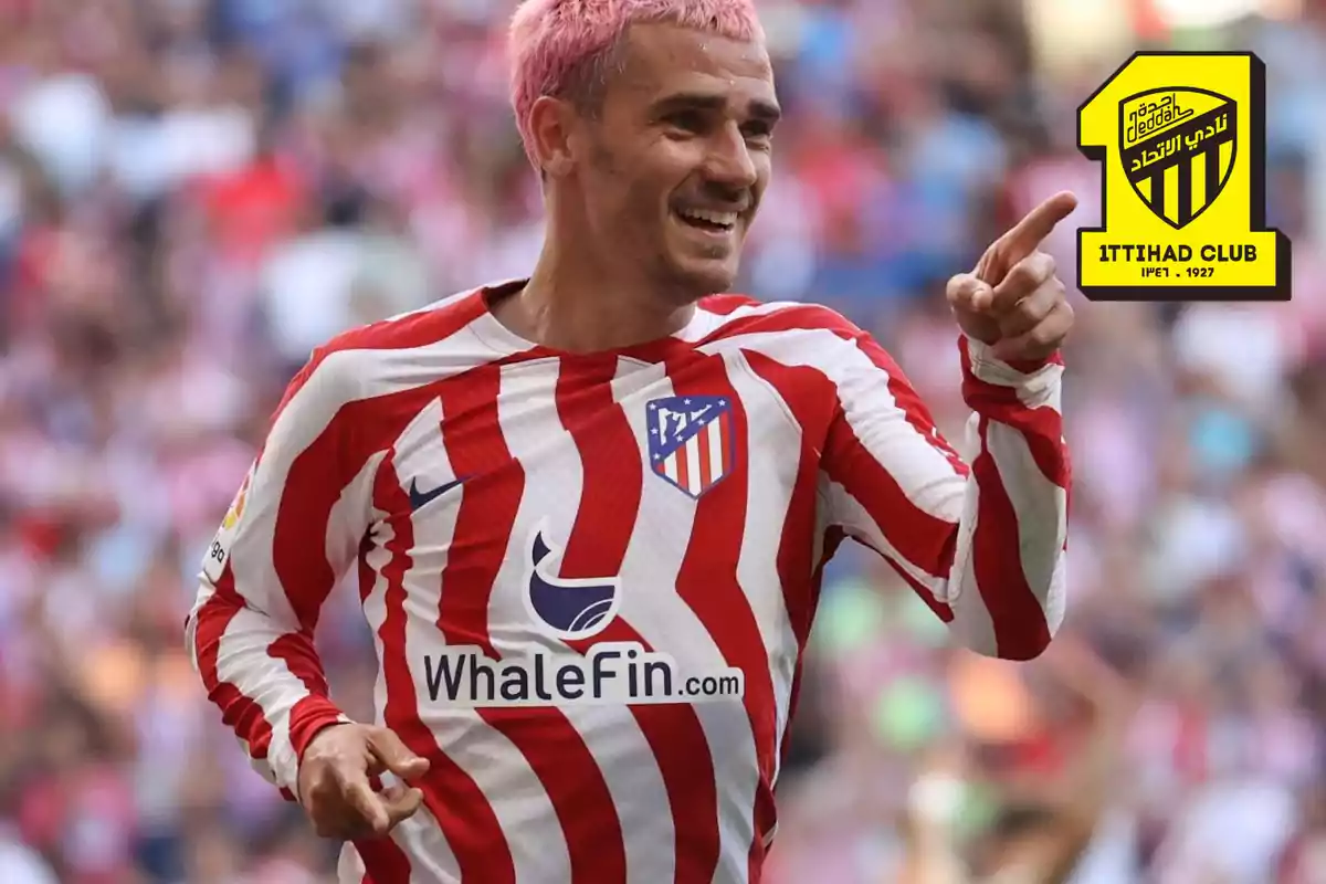 Football player in a red and white striped Atlético de Madrid shirt, pointing with his finger, with an Ittihad Club logo in the upper right corner.