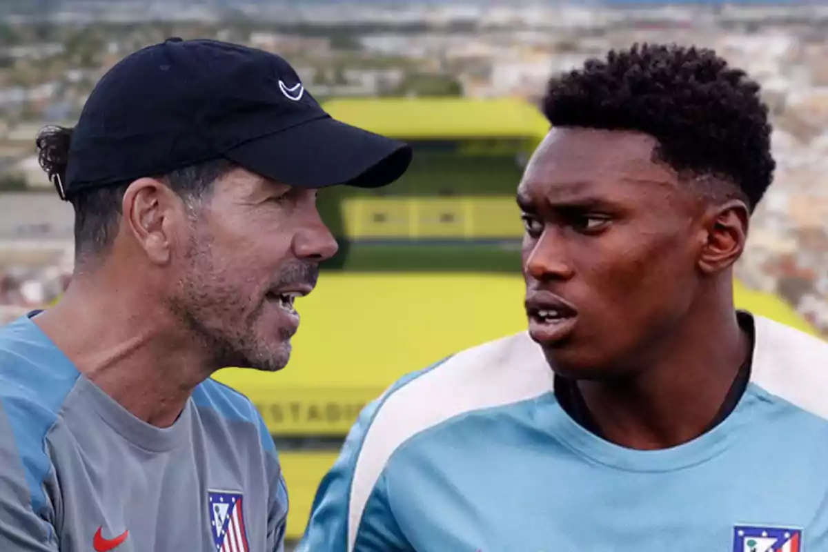 A football coach talking to a player in a stadium.