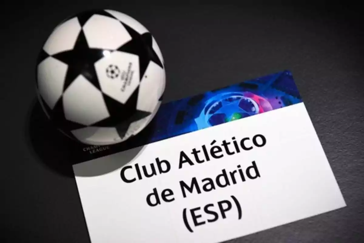 UEFA Champions League ball next to a card with the name of Club Atlético de Madrid (ESP).